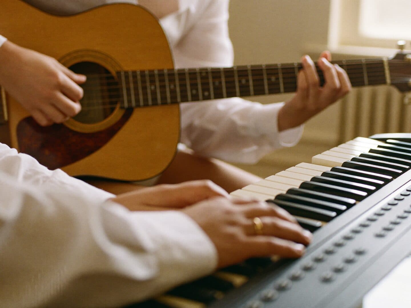 A trainer guiding a student at the piano during a one-to-one lesson
